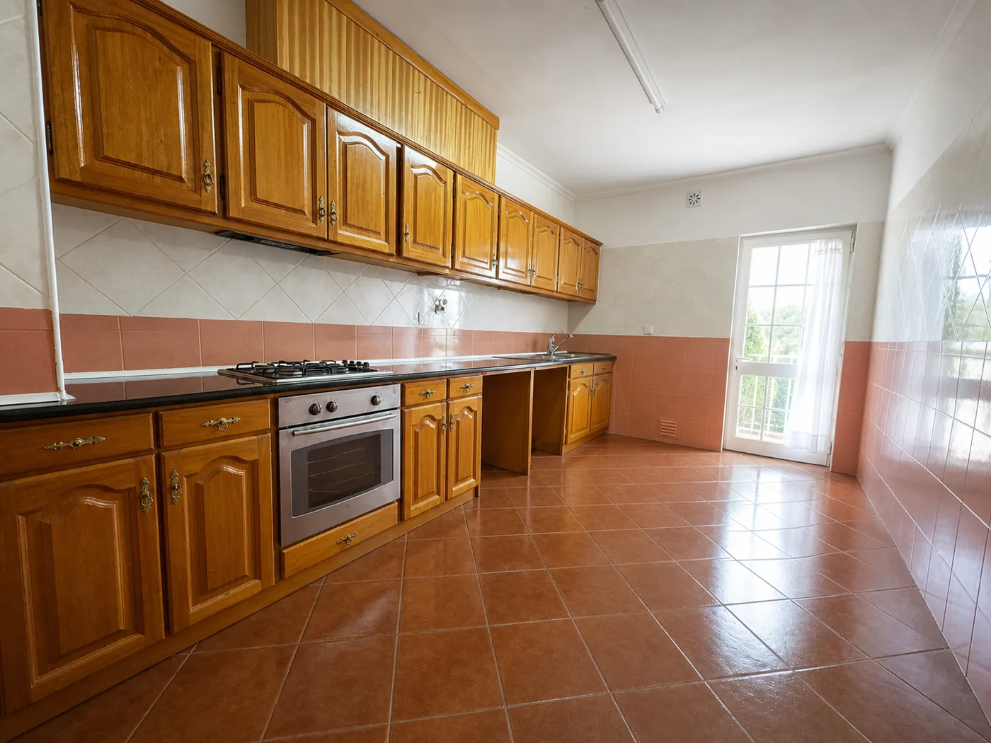 Cozinha original, com armários em madeira envernizada e azulejo até meia altura